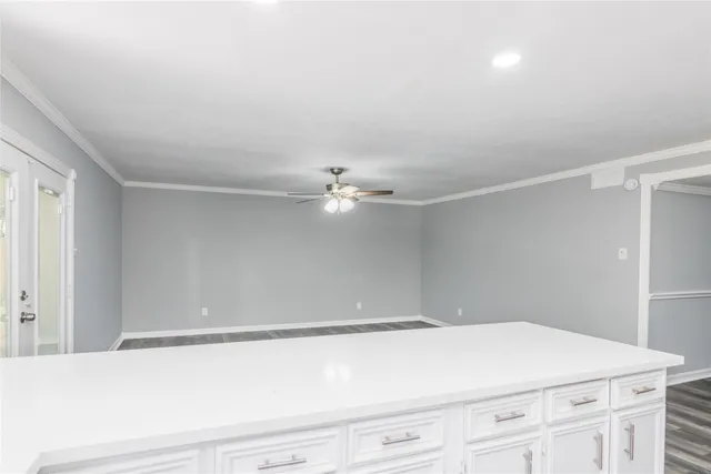 a room with a white cabinet and a ceiling fan