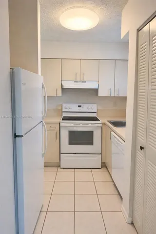 a kitchen with a stove top oven and cabinets