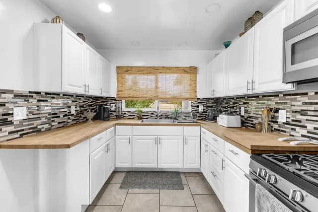 a kitchen with granite countertop a sink stove and cabinets