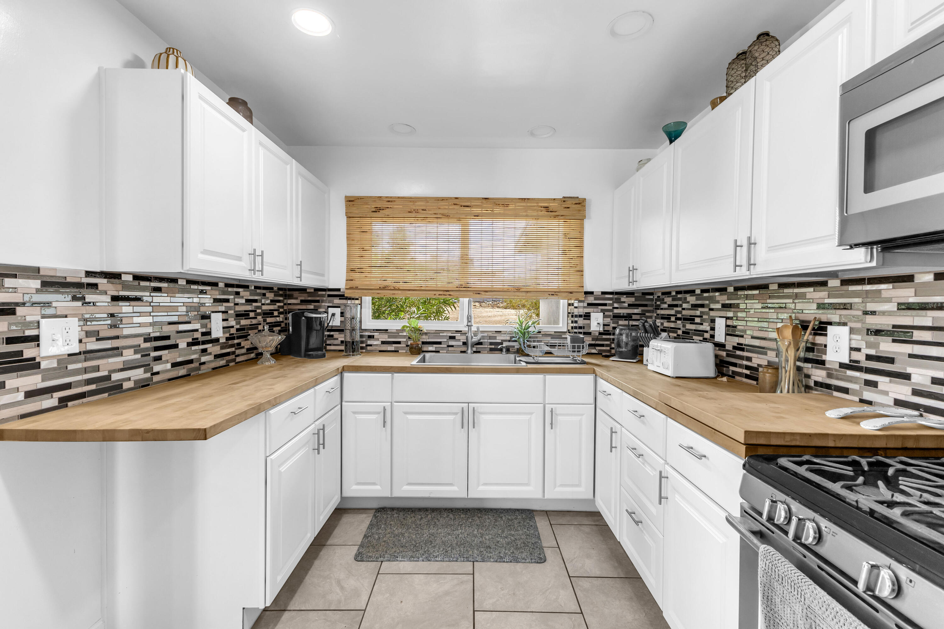75047 Baseline Road Twentynine Palms, CA 92277 - Photo 14 of 47 a kitchen with granite countertop a sink stove and cabinets