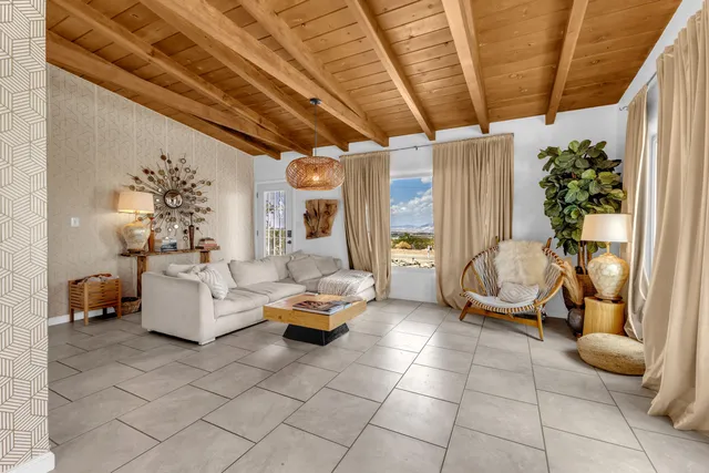 a living room with patio furniture and a potted plant