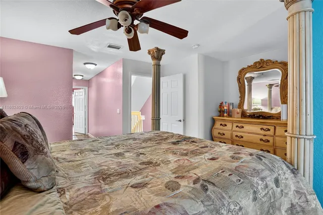 a bedroom with a bed and a mirror on the dresser