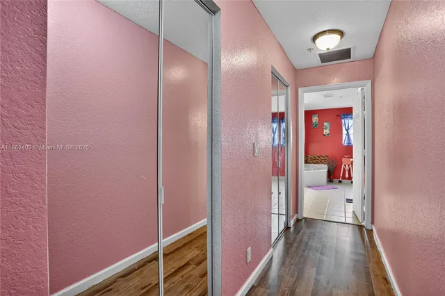 a view of a hallway with wooden floor