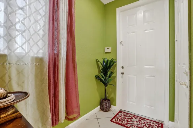a room with a door and a potted plant