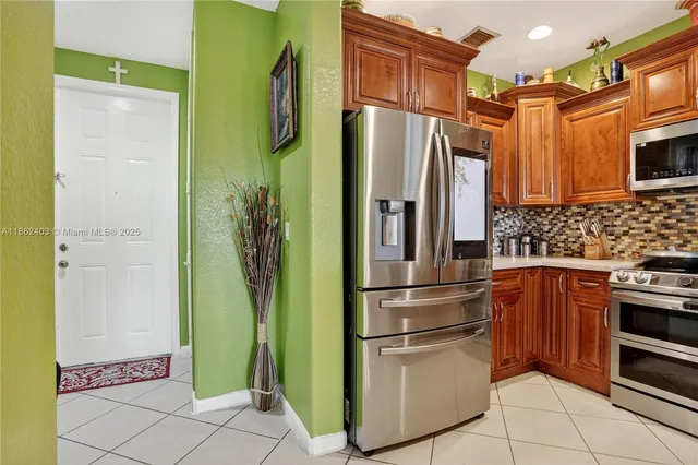 a kitchen with stainless steel appliances a refrigerator and a stove top oven
