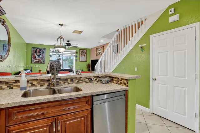 a room with kitchen island a sink a stove and a wooden floors