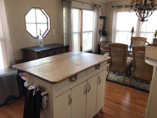 55 Boca Chica Road, Unit 32 Key West, FL 33040 - Photo 12 of 27 an open kitchen with a table chairs and wooden floor