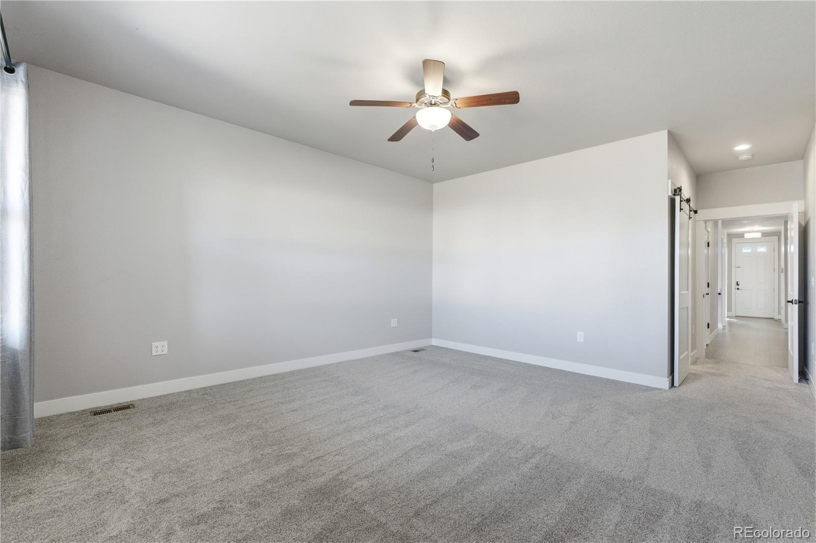 1908 Tidewater Lane Windsor, CO 80550 - Photo 11 of 41 an empty room with chandelier fan and windows
