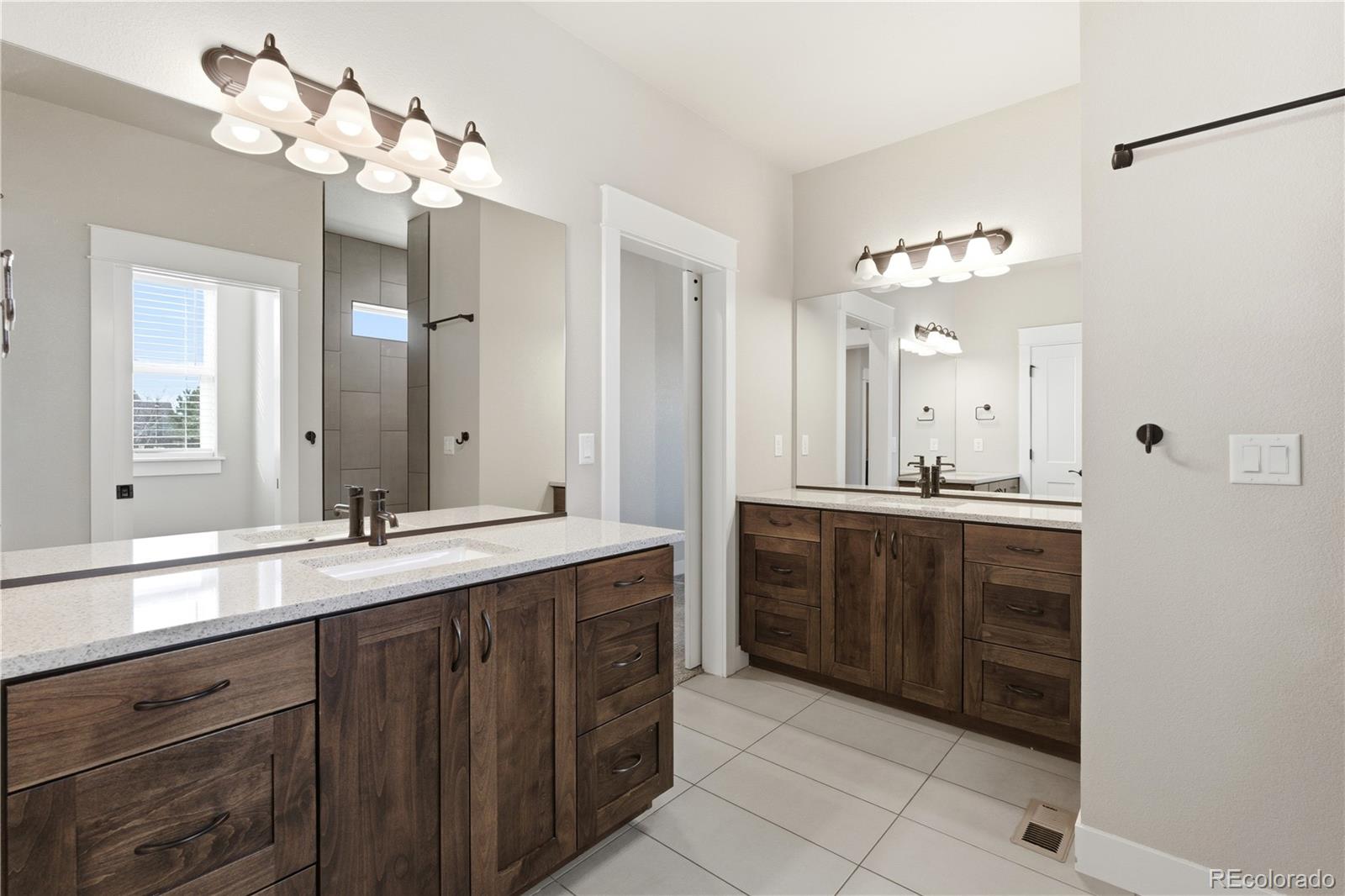 1908 Tidewater Lane Windsor, CO 80550 - Photo 13 of 41 a bathroom with a double vanity sink and a mirror