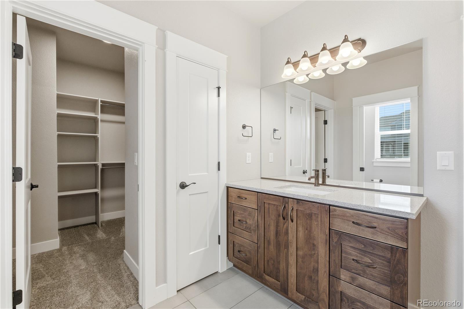 1908 Tidewater Lane Windsor, CO 80550 - Photo 15 of 41 a bathroom with a sink vanity and a mirror