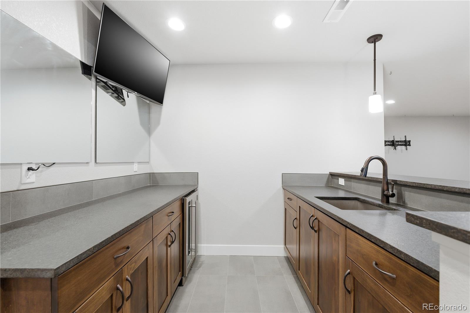 1908 Tidewater Lane Windsor, CO 80550 - Photo 23 of 41 a kitchen with stainless steel appliances a sink a stove and a wooden floor