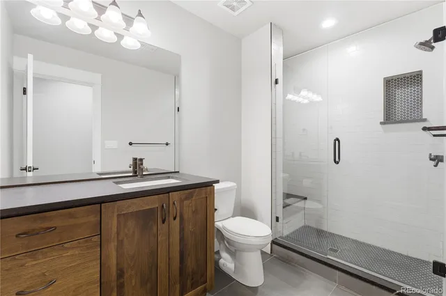 a bathroom with a granite countertop sink a toilet and a mirror