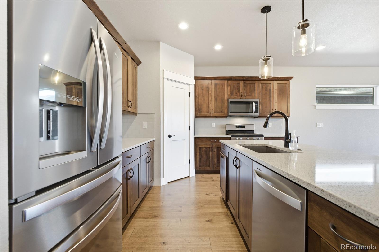 1908 Tidewater Lane Windsor, CO 80550 - Photo 9 of 41 a kitchen with stainless steel appliances granite countertop a sink and a refrigerator