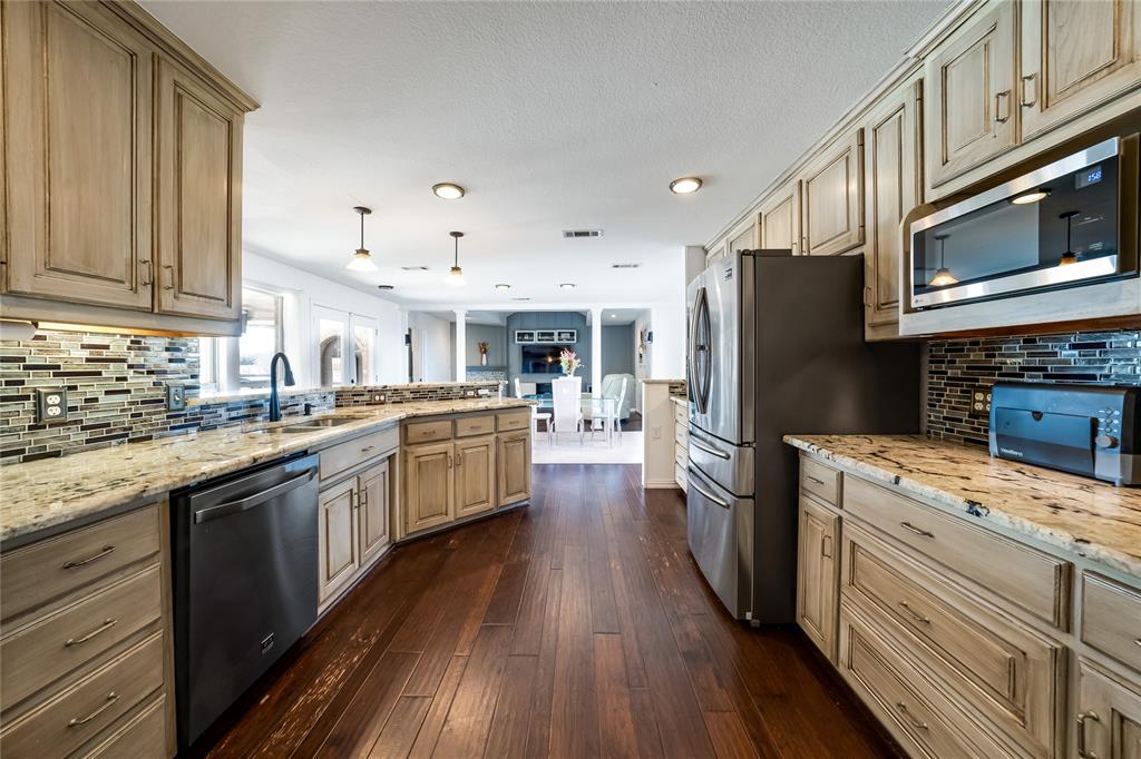 750 Long Road Lucas, TX 75002 - Photo 14 of 39 a kitchen with a sink wooden floor and stainless steel appliances