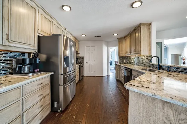 a kitchen with a sink refrigerator and cabinets