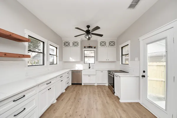 a view of an empty room with a window and wooden floor