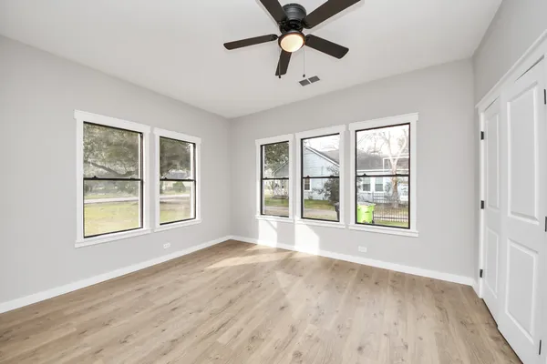 a view of a big room with wooden floor and windows