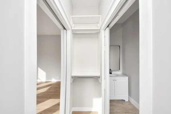 a view of a big room with wooden floor closet and windows