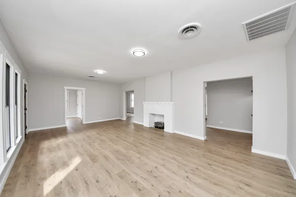 a view of empty room with wooden floor and entryway