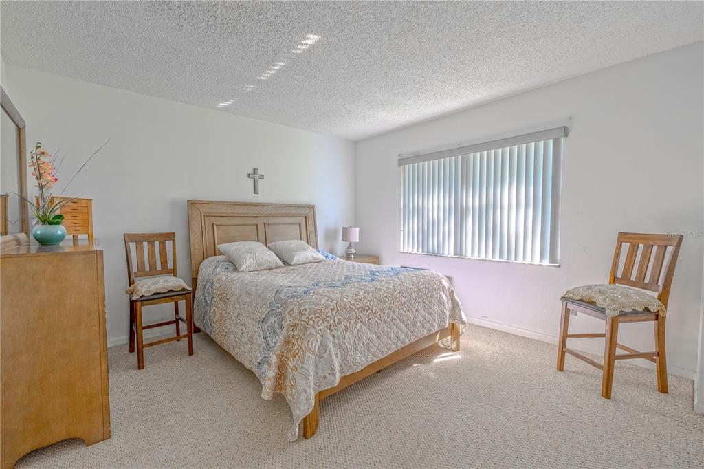 1131 Orange Tree Circle West, Unit C Palm Harbor, FL 34684 - Photo 14 of 28 a bedroom with a bed chair and window