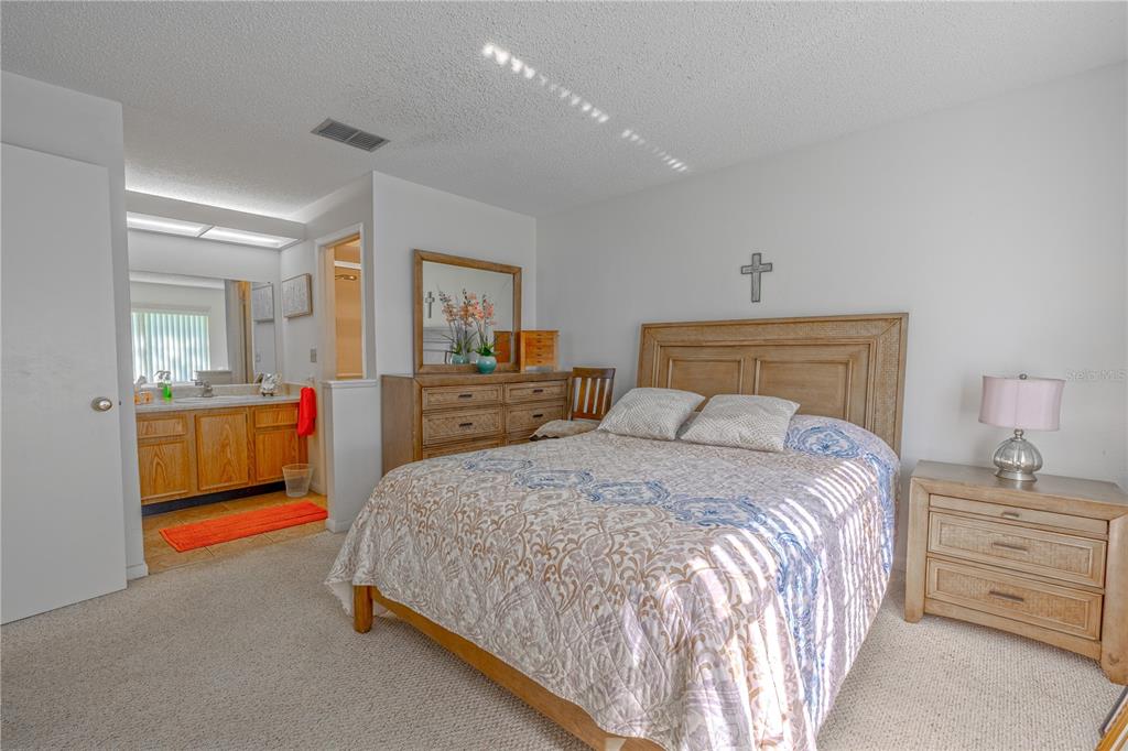 1131 Orange Tree Circle West, Unit C Palm Harbor, FL 34684 - Photo 15 of 28 a bedroom with a bed and a view of kitchen