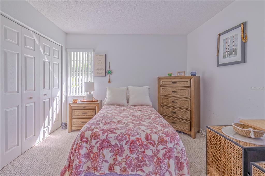 1131 Orange Tree Circle West, Unit C Palm Harbor, FL 34684 - Photo 20 of 28 a bedroom with a bed and a cabinets
