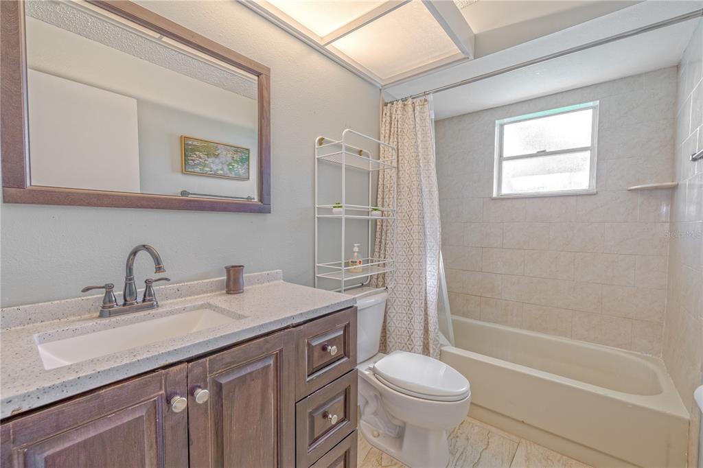 1131 Orange Tree Circle West, Unit C Palm Harbor, FL 34684 - Photo 21 of 28 a bathroom with a sink a toilet and shower