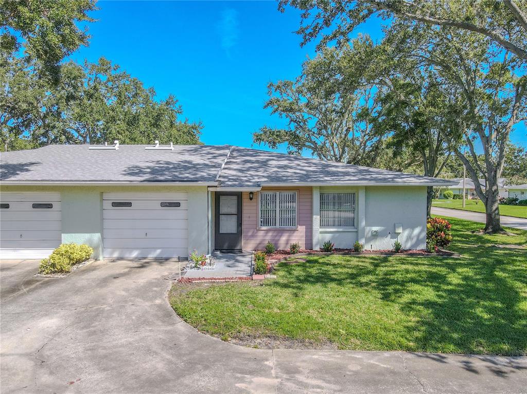 1131 Orange Tree Circle West, Unit C Palm Harbor, FL 34684 - Photo 23 of 28 front view of a house with a yard