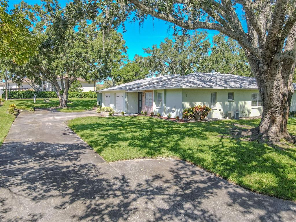 1131 Orange Tree Circle West, Unit C Palm Harbor, FL 34684 - Photo 24 of 28 a front view of a house with garden