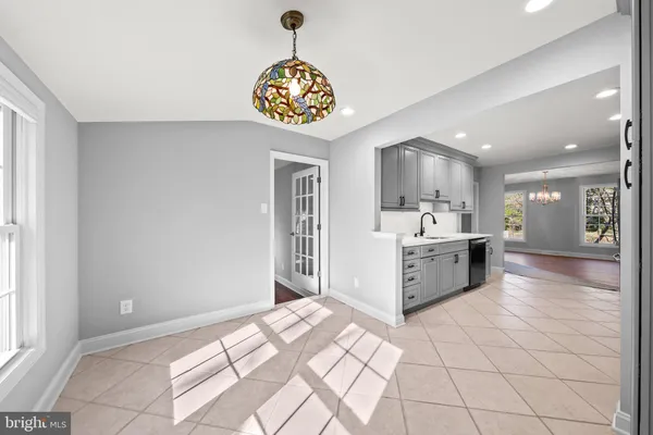 a large white kitchen with a stove a sink dishwasher and a refrigerator