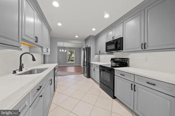 a kitchen with stainless steel appliances granite countertop a sink and white cabinets