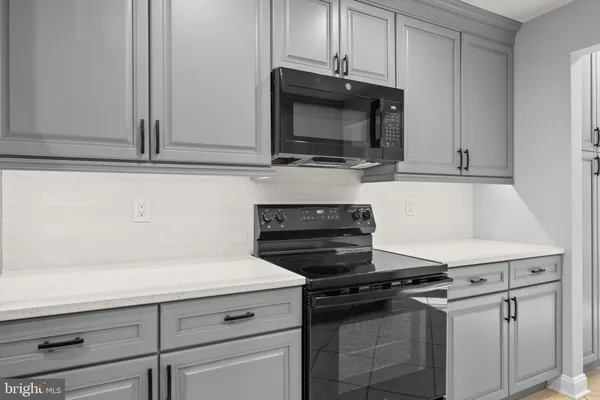 a kitchen with microwave cabinets and stove top oven