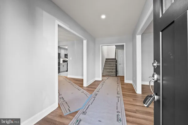 a view of a hallway with wooden floor and staircase