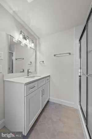 a bathroom with a double vanity sink mirror and shower