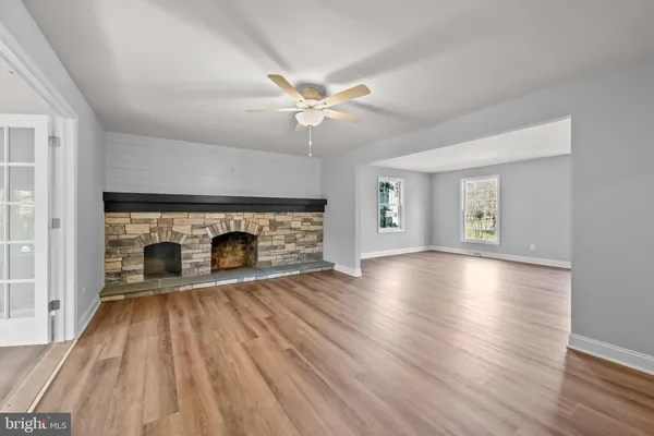 wooden floor fireplace and windows in an empty room