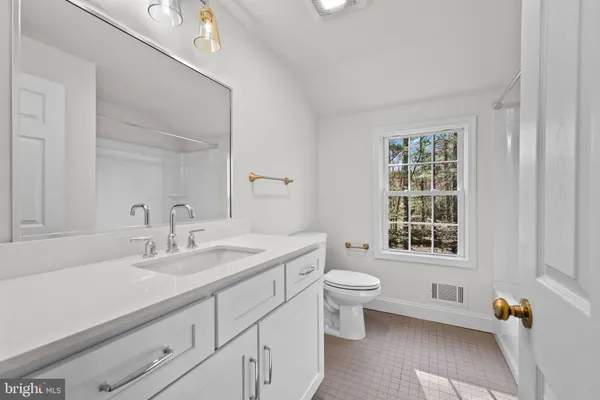 a bathroom with a sink toilet and a mirror