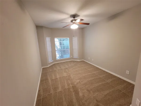 a view of an empty room with a chandelier fan