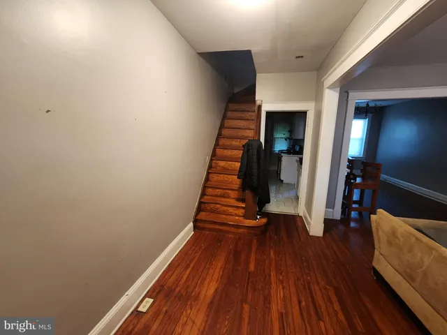 a view of a hallway with wooden floor and stairs