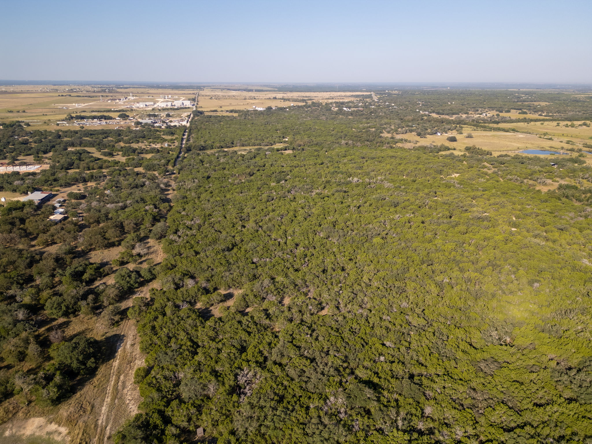 112 Loop 308 Briggs, TX 78608 - Photo 24 of 37 Aerial view of property and surrounding area featuring a heavily wooded area