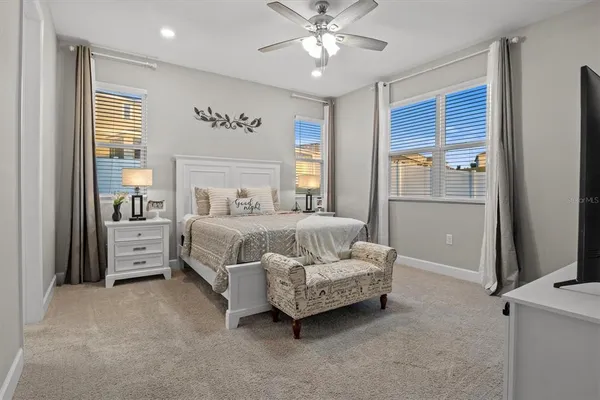 a spacious bedroom with a bed and a chandelier