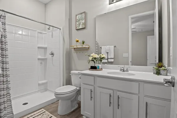 a bathroom with a sink toilet a mirror and shower