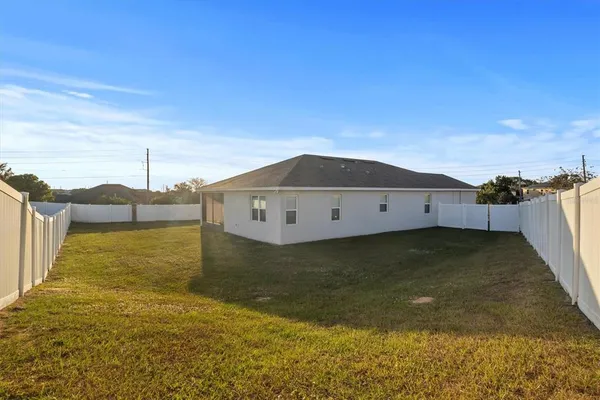 a view of a big yard with wooden fence