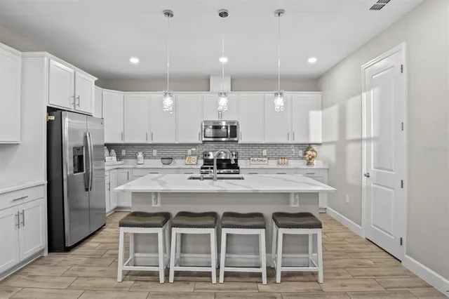 a kitchen with kitchen island cabinets and refrigerator