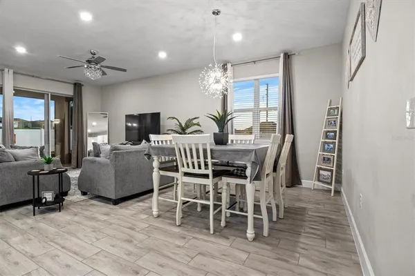 a dining room with furniture a chandelier and wooden floor