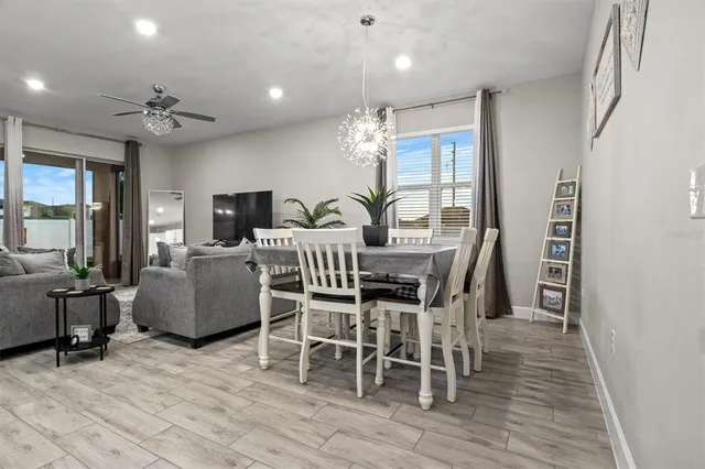 a dining room with furniture a chandelier and wooden floor