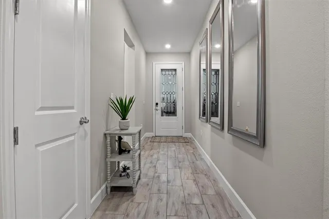 a hallway with wooden floor table and chairs