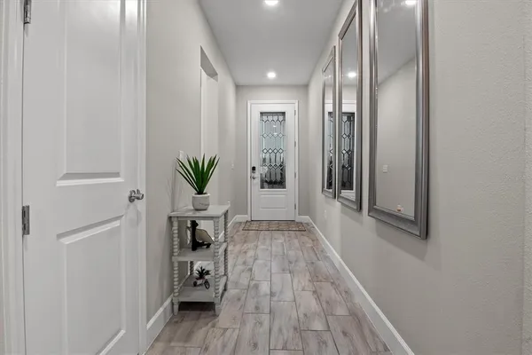 a hallway with wooden floor table and chairs