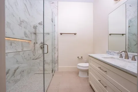 a bathroom with a granite countertop sink toilet and shower