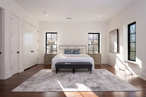 a spacious bedroom with a bed and wooden floor