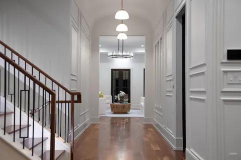 a view of a hallway with wooden floor and staircase